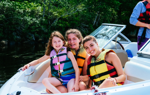 campers and staff on a motorboat