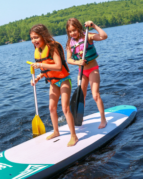 campers stand up paddle boarding