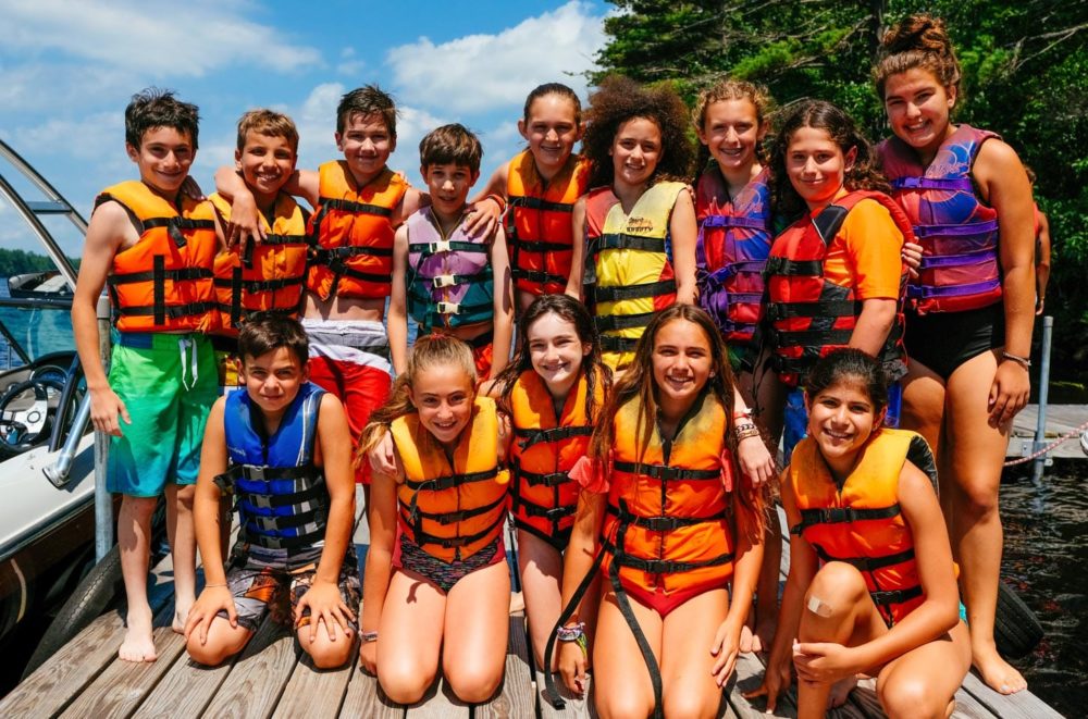 group of campers in life jackets by dock