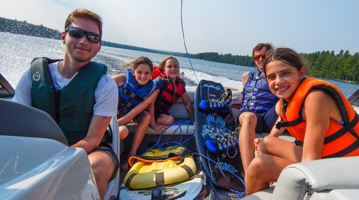 staff and campers on a motorboat