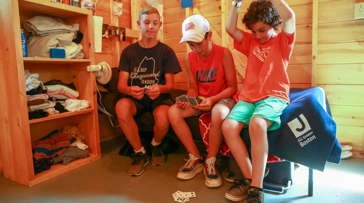 boys playing cards in a cabin