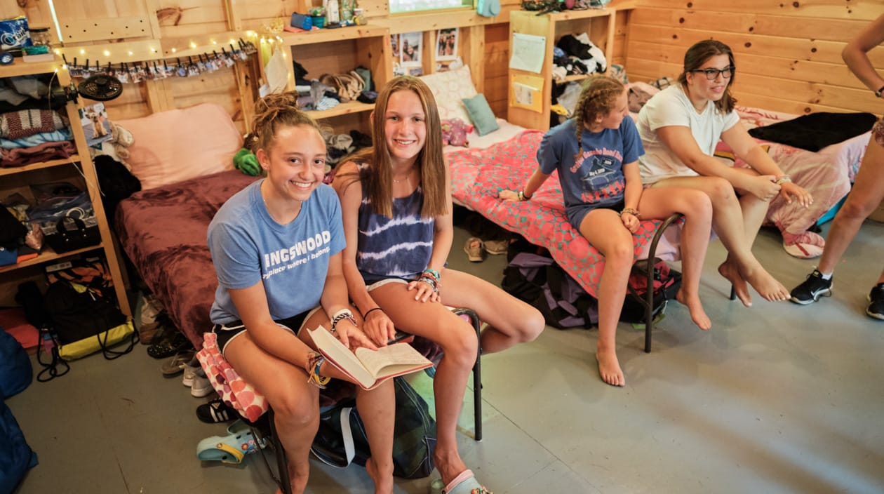 girls sitting on bed in cabin