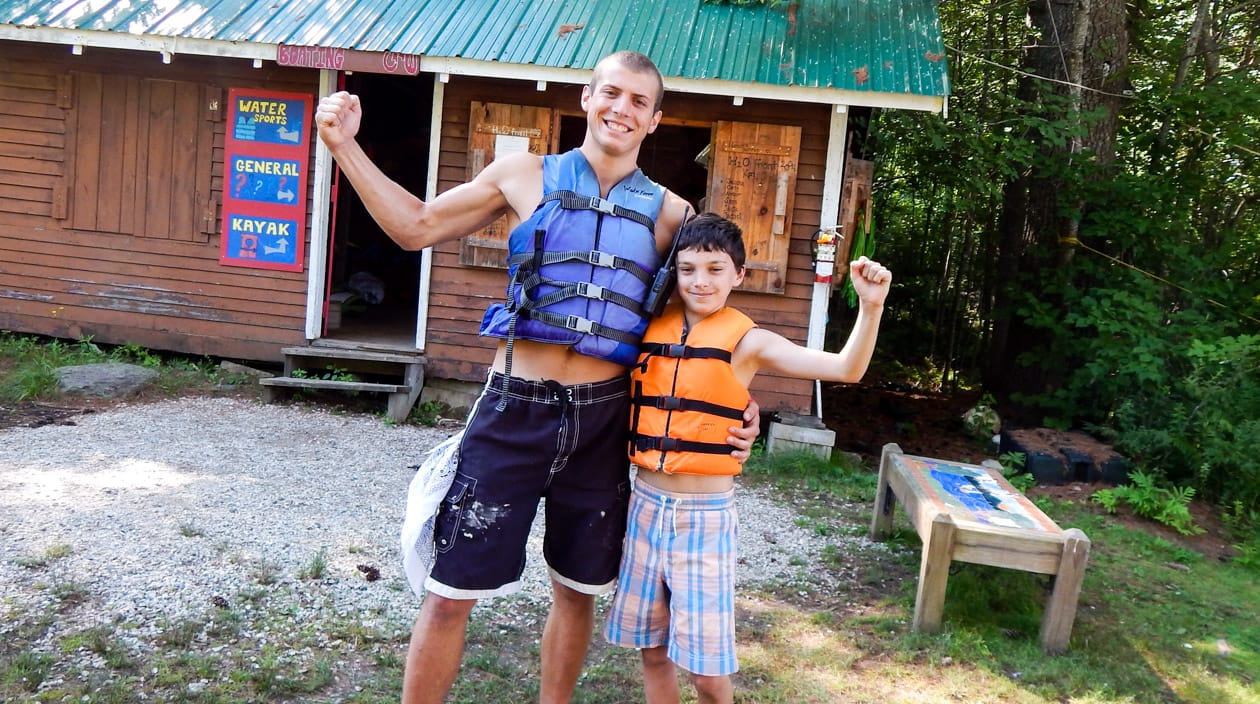 staff and camper wearing life jackets