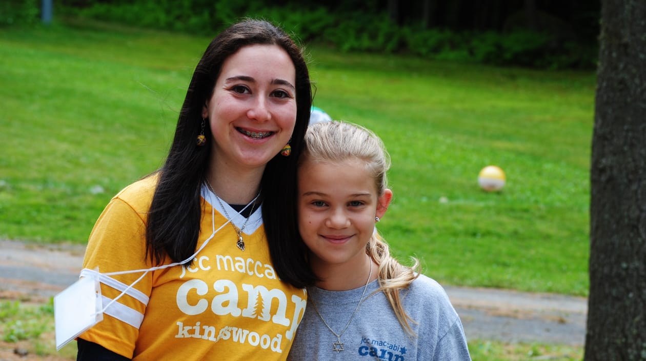 staff and camper smiling