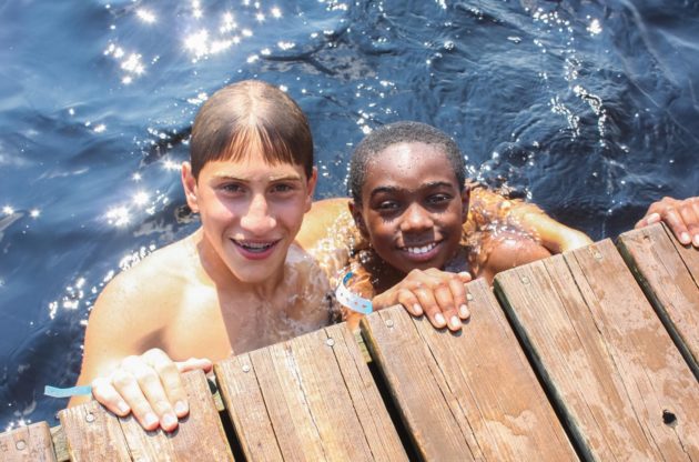 two boys swimming in a lake