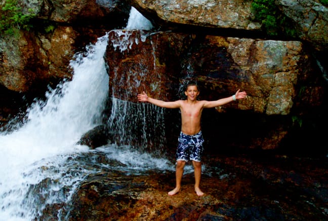 boy by waterfall
