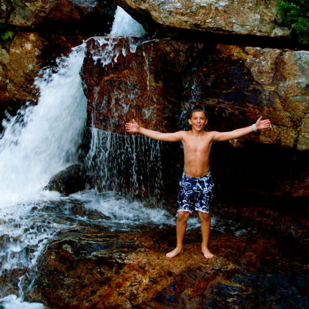 boy by waterfall