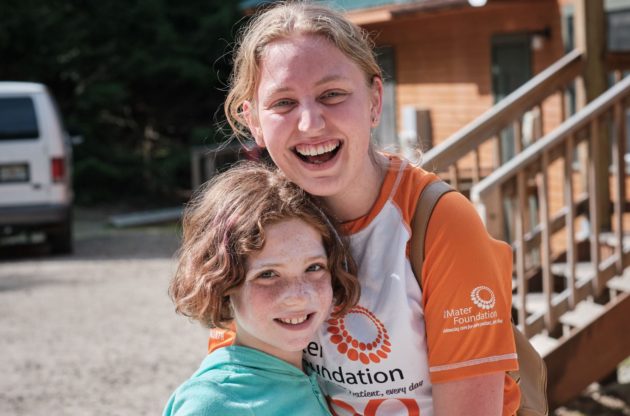 young female camper next to staff