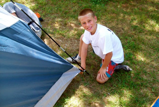 boy setting up a tent