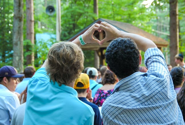 boys by the chapel making a heart with their hands
