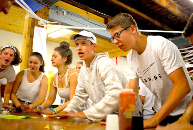 campers doing a drumroll at the dining hall