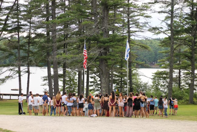 campers by flag pole