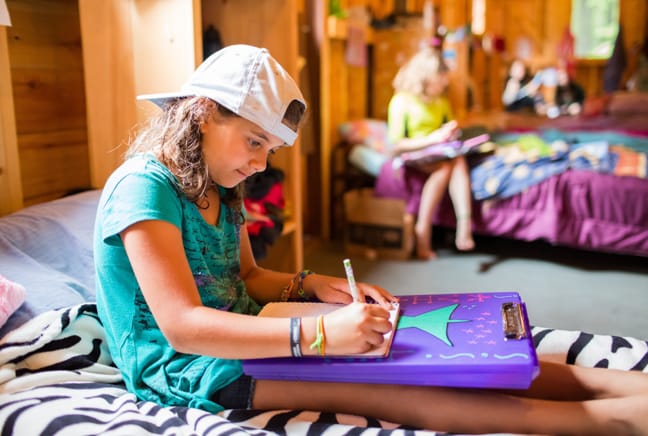girl writing in the bunk