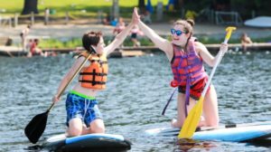 campers high fiving on sup board