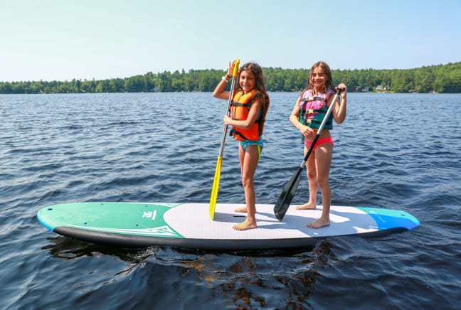 two girls on a stand up paddleboard